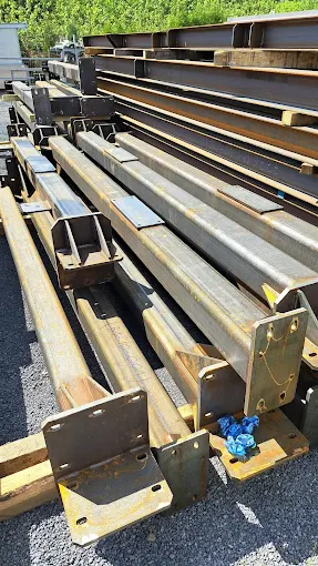 Stalowe belki konstrukcyjne ułożone na placu składowym